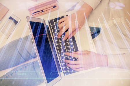 Double exposure of woman hands working on computer and forex graph hologram drawing. Top View....