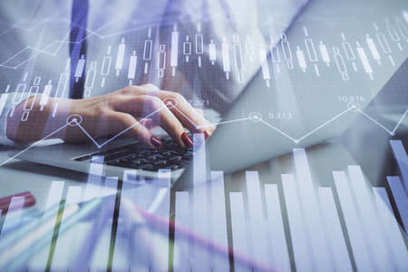 Double exposure of woman hands typing on computer and financial graph hologram drawing. Stock market...
