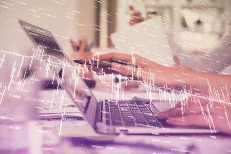 Multi exposure of woman hands typing on computer and financial graph hologram drawing. Stock market...