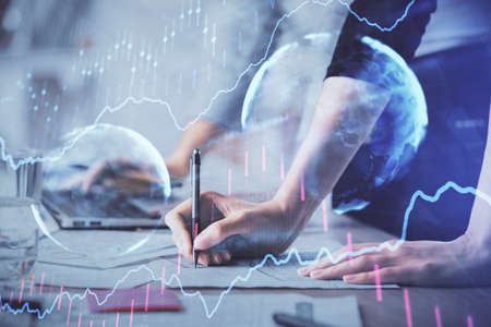 Multi exposure of woman hands typing on the computer and financial chart hologram drawing. Stock...