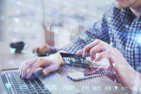 Double exposure of man hands holding a credit card and Forex graph drawing. Stock trading and...