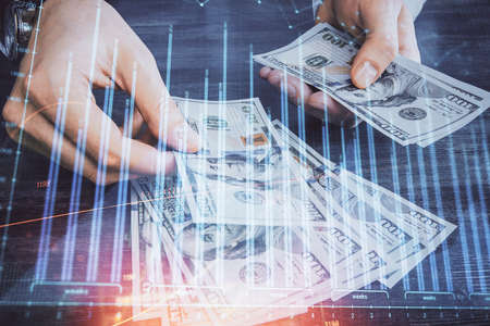 Multi exposure of financial graph drawing hologram and USA dollars bills and man hands. Analysis concept.の写真素材