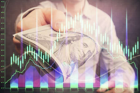 Multi exposure of financial graph drawing hologram and USA dollars bills and man hands. Analysis...