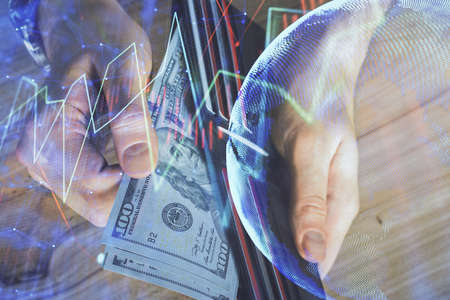 Multi exposure of forex graph drawing hologram and USA dollars bills and man hands. Technical...