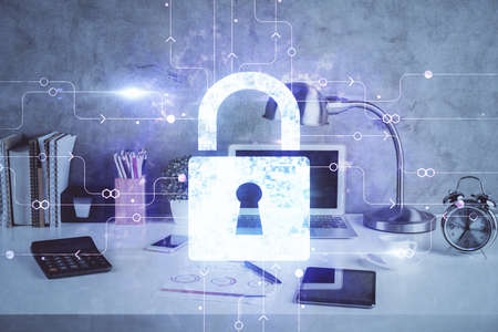 Double exposure of desktop with computer and lock icon hologram. Concept of data safety.