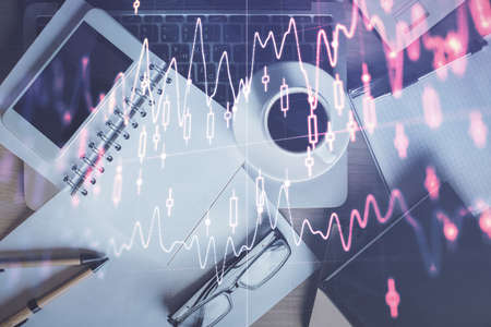 Double exposure of financial graph hologram over desktop with phone. Top view. Mobile trade platform...