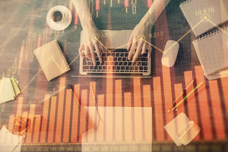 Multi exposure of woman hands working on computer and forex chart hologram drawing. Top View. Financial analysis concept.の写真素材