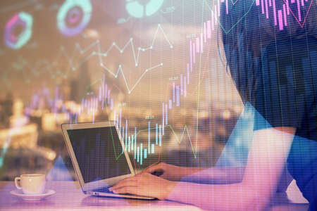 Double exposure of businesswoman hands typing on computer and forex chart hologram drawing....