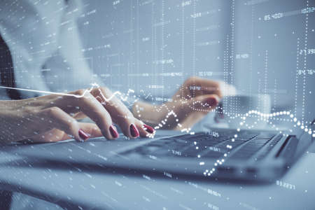Multi exposure of woman hands typing on computer and financial graph hologram drawing. Stock market...