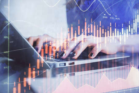 Double exposure of woman hands typing on computer and forex chart hologram drawing. Stock market...