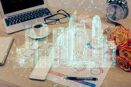 Desktop computer background in office and big town buildings hologram drawing. Double exposure. Smart city concept.の写真素材
