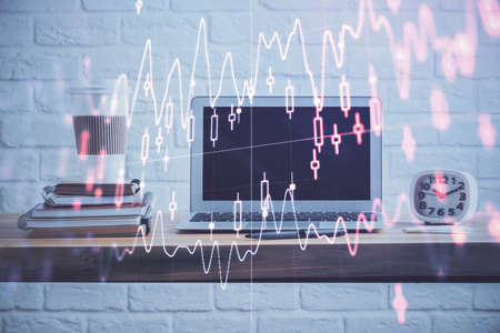 Stock market chart hologram drawn on personal computer background. Double exposure. Concept of investment.の写真素材