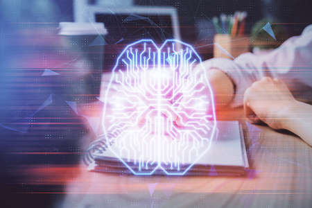 Multi exposure of writing hand on background with brain hologram. Concept of learning.の写真素材