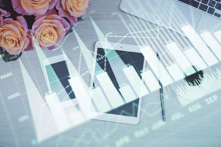 Double exposure of forex graph hologram over desktop with phone. Top view. Mobile trade platform concept.の写真素材