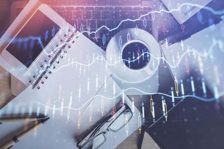 Double exposure of financial graph hologram over desktop with phone. Top view. Mobile trade platform...