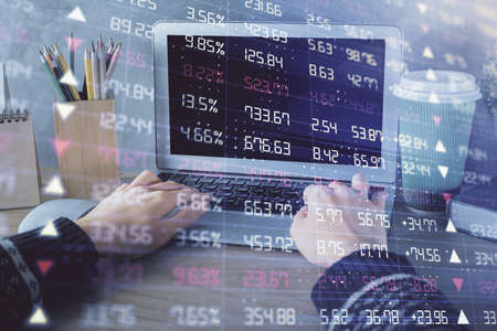 Double exposure of woman hands typing on computer and forex chart hologram drawing. Stock market...