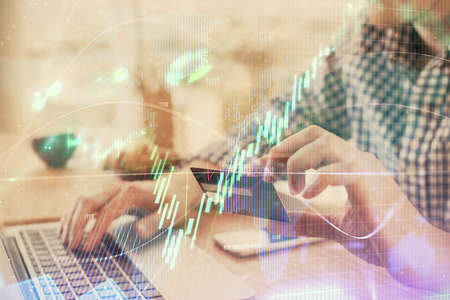 Double exposure of man hands holding a credit card and Forex graph drawing. Stock trading and...