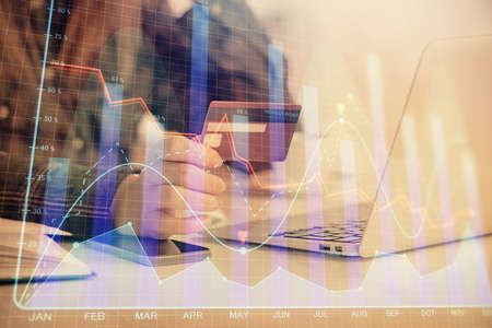 Multi exposure of woman on-line shopping holding a credit card and financial graph drawing. Stock...