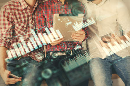Double exposure of forex graph drawing and man and woman working together holding and using a mobile device. Trade concept.の写真素材
