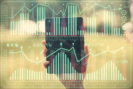 Double exposure of forex chart sketch hologram and woman holding and using a mobile device....