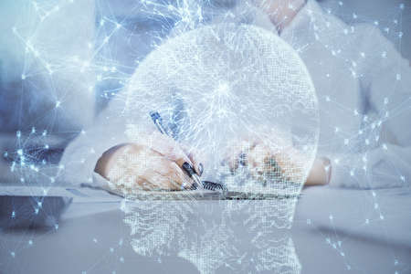 Multi exposure of writing hand on background with brain hologram. Concept of self learning.の写真素材