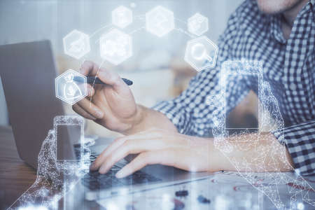 Technology theme hologram with man working on computer on background. High tech concept. Double...