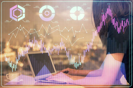 Double exposure of businesswoman hands typing on computer and forex chart hologram drawing....