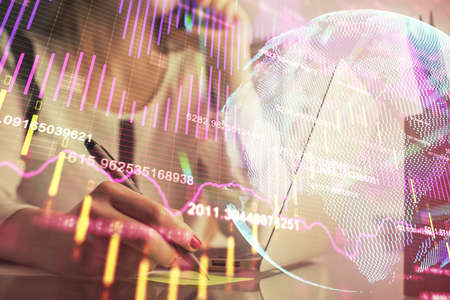 Double exposure of woman hands typing on computer and financial graph hologram drawing. Stock market...