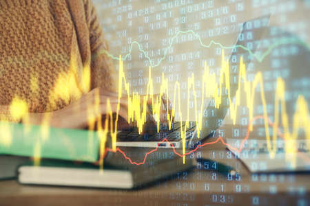 Double exposure of woman hands typing on computer and forex chart hologram drawing. Stock market...