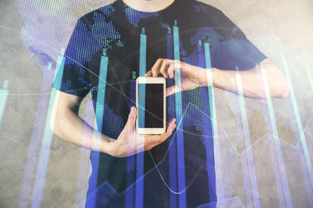 Double exposure of mans hands holding and using a digital device and forex graph drawing. Financial...
