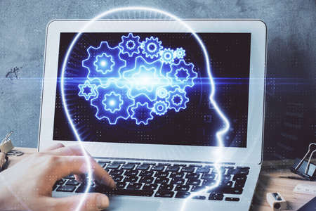 Businessman with computer background with brain theme hologram. Concept of brainstorm. Multi...