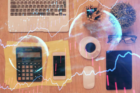 Double exposure of forex chart hologram over desktop with phone. Top view. Mobile trade platform concept.の写真素材