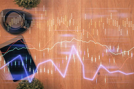 Multi exposure of financial chart hologram over desktop with phone. Top view. Mobile trade platform...