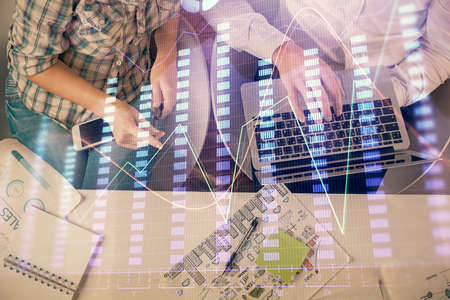 Multi exposure of man and woman working together and forex graph hologram drawing. Financial...