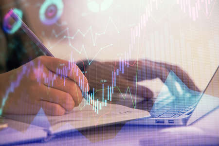 Double exposure of businesswoman hands typing on computer and forex chart hologram drawing....