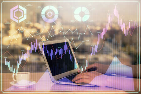 Double exposure of businesswoman hands typing on computer and forex chart hologram drawing....