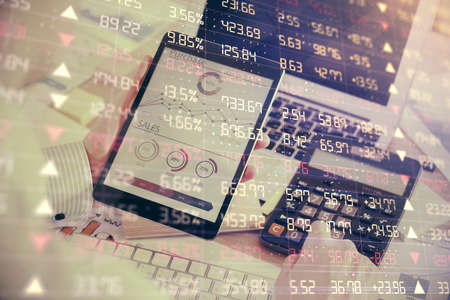 Double exposure of mans hands holding and using a digital device and forex graph drawing. Financial...