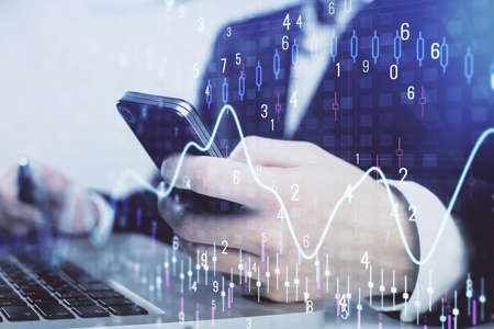 Multi exposure of man's hands holding and using a digital phone and forex graph drawing. Financial...