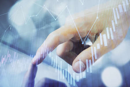 Multi exposure of man's hands holding and using a phone and financial chart drawing. Market analysis...