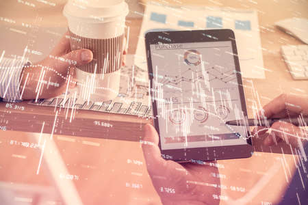 Double exposure of mans hands holding and using a phone and financial chart drawing. Market analysis concept.の写真素材