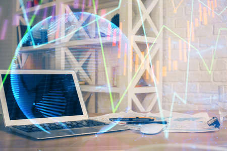 Financial graph colorful drawing and table with computer on background. Double exposure. Concept of international markets.の写真素材