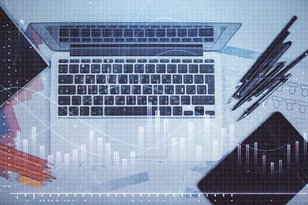Multi exposure of forex chart drawing over table background with computer. Concept of financial...