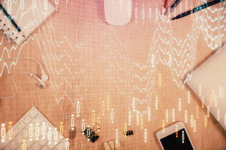 Multi exposure of forex graph hologram over desktop with phone. Top view. Mobile trade platform...