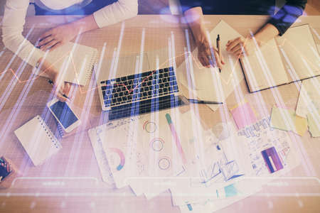 Double exposure of woman hands working on computer and forex graph hologram drawing. Top View....