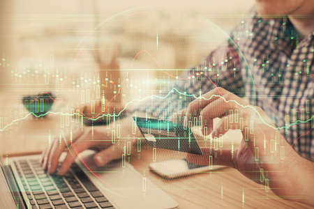 Double exposure of man hands holding a credit card and Forex graph drawing. Stock trading and...