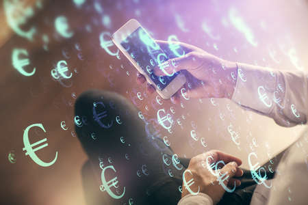 Double exposure of mans hands holding and using a digital device and forex graph drawing. Financial...