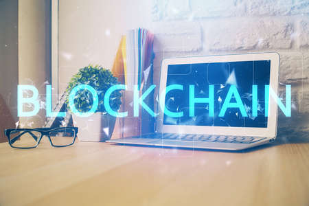 Double exposure of blockchain theme hologram and table with computer background. Concept of bitcoin crypto currency.の写真素材