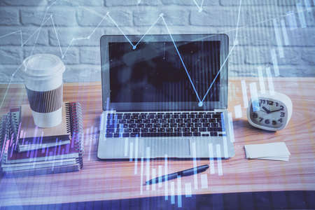 Double exposure of graph and financial info and work space with computer background. Concept of international online trading.の写真素材