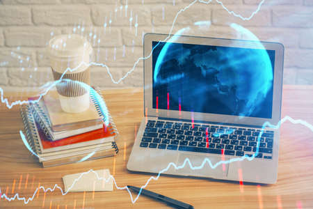 Double exposure of chart and financial info and work space with computer background. Concept of...