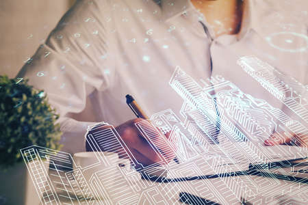 Abstract holographic city on mans hand writing notes background. Multi exposure.